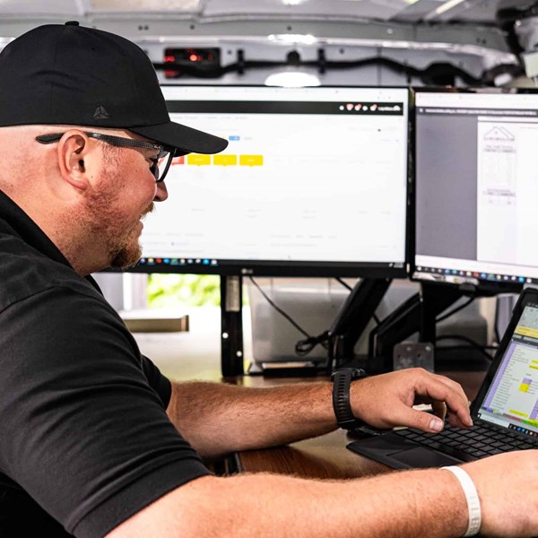 Man seated at a desk viewing a laptop.