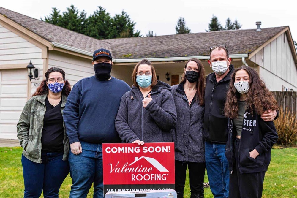 Holly and her family in front of her house with a new roof